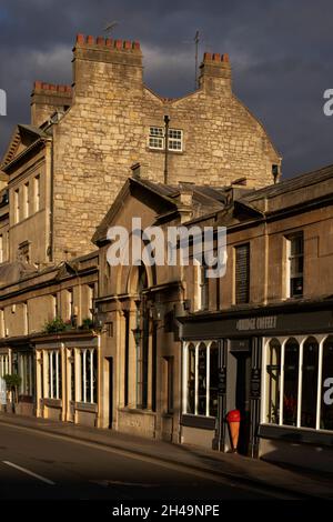 Edifici illuminati dal sole che circondano Pulteney Bridge sul fiume Avon nella storica città di Bath nel Regno Unito Foto Stock