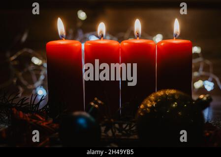 Quattro candele rosse dell'avvento con quattro candele accese e decorazione  di natale che giace nella neve come modello Foto stock - Alamy