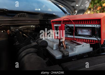 Un morsetto rosso fissato alla batteria dell'auto per la ricarica, Danimarca, 1° novembre 2021 Foto Stock