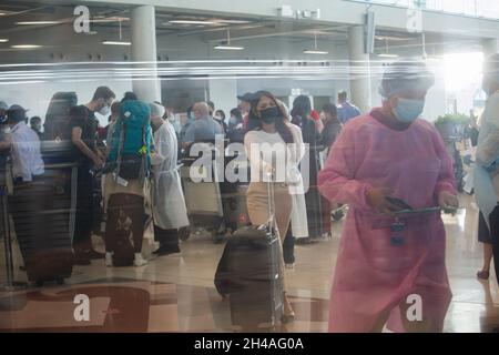 Samut Prakan, Tailandia. 01 Novembre 2021. I viaggiatori che indossano le maschere come misure preventive contro Covid-19 escono da un checkpoint personalizzato all'aeroporto di Suvarnabhumi.Thailand riapre il paese il 1 novembre a viaggiatori completamente vaccinati da paesi di basso rischio a coronavirus pandemic senza subire i requisiti di quarantena. Questo obiettivo è quello di stimolare l'industria e l'economia del turismo. Credit: SOPA Images Limited/Alamy Live News Foto Stock