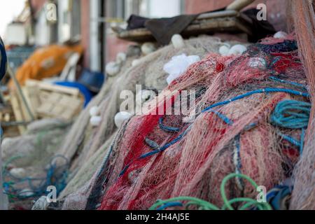 Reti da pesca impilate e corde rosse verdi e bianche spesse e sottili Foto Stock