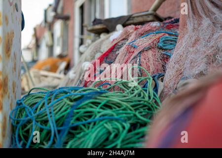 Reti da pesca impilate e corde rosse, verdi, blu e bianche Foto Stock