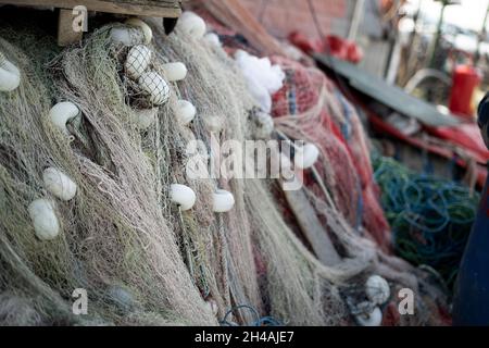 Reti da pesca impilate e corde rosse, verdi, blu e bianche Foto Stock