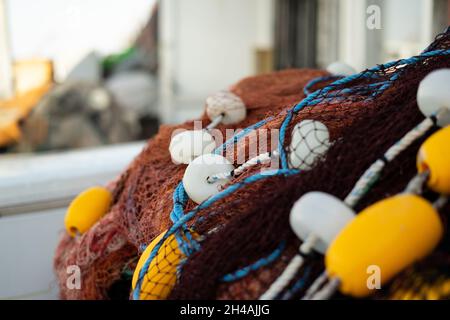 Reti da pesca impilate e corde rosse, verdi, blu e bianche Foto Stock