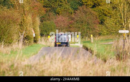 Black Ford Transit furgone personalizzato che guida attraverso la panoramica campagna autunnale Foto Stock