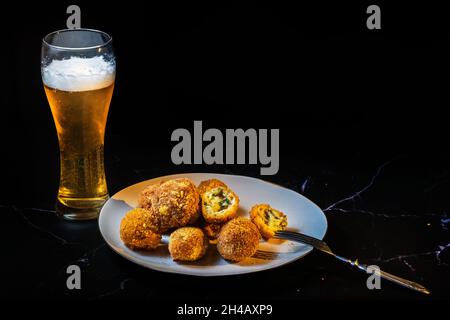 palle di formaggio con aglio e aneto all'interno per uno spuntino con un bicchiere di birra. Foto Stock