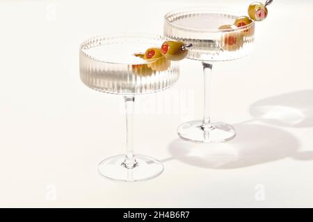 Due vodka o gin martini con olive su sfondo bianco Foto Stock