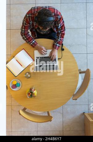 Vista dall'alto dello sviluppatore con un notebook, un notebook, cibo e bevande Foto Stock