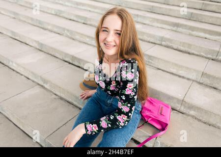 Ragazza adolescente sdraiata sulle scale con accessori Foto Stock