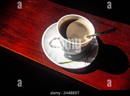 Una tazza di caffè su un piattino, con un cucchiaio di caffè, Cartagena de Indias, Colombia. Foto Stock