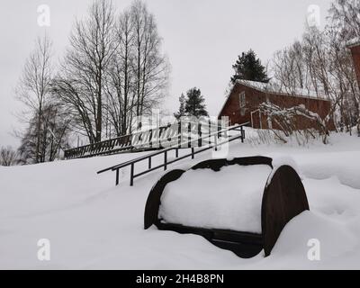 Cabine rosse in legno in una foresta. Tempo nevoso. Foto Stock