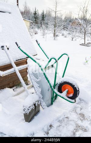 Carriola da giardino in metallo nella neve in inverno Foto Stock