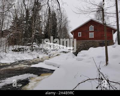 Cabine rosse in legno in una foresta. Tempo nevoso. Foto Stock