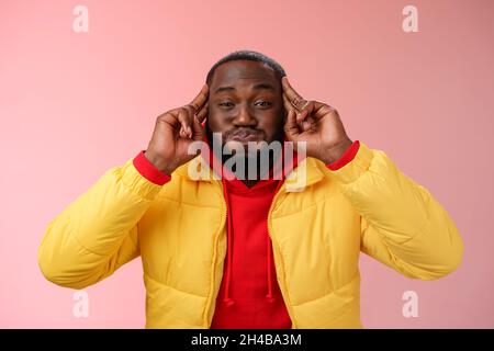 Informazioni di soffio mentale. Ritratto giocoso carismatico spensierato africano sopportato giovane 25s uomo che pointing trattenga alito peperoncino avendo divertimento comportarsi immaturo Foto Stock