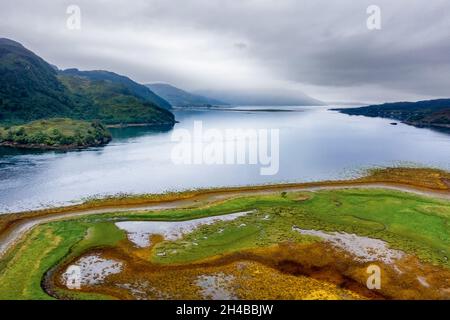 Scenario suggestivo in un lago marino scozzese in un pomeriggio nuvoloso e grigio (Loch Duich, Eilean Donan) Foto Stock