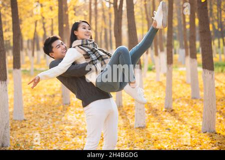 Giovane uomo che raccoglie la sua ragazza Foto Stock