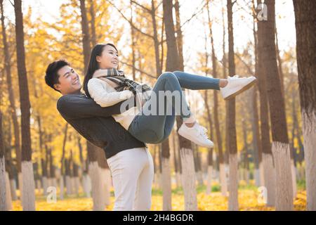 Giovane uomo che raccoglie la sua ragazza Foto Stock