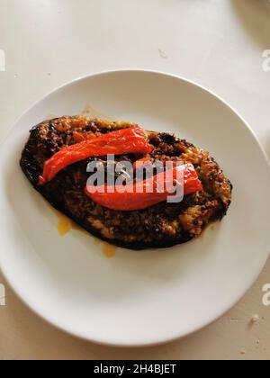 Melanzane farcite con carne tritata e cotte in forno su tavola bianca. Foto Stock