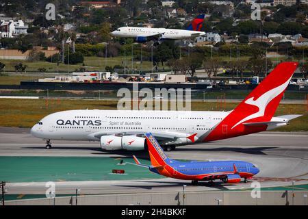 Los Angeles, California, Stati Uniti. 28 marzo 2019. Un Qantas Airbus se A380-800 (registrazione VH-OQA) decollo come Delta Air Lines Airbus A319 (registrazione N302NB) atterra e un Southwest Airlines Boeing Co. 737 taxi presso l'aeroporto internazionale di Los Angeles (LAX) giovedì 28 marzo 2019 a Los Angeles, California © 2019 Patrick T. Fallon. (Credit Image: © Patrick Fallon/ZUMA Press Wire) Foto Stock