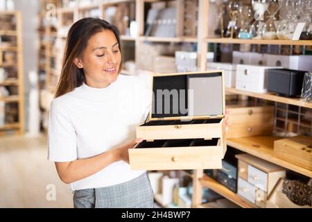 Donna ispanica che acquista contenitori di stoccaggio per gioielli in negozio Foto Stock