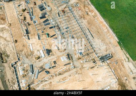 edifici industriali in costruzione. vista aerea di grandi cantieri con materiali da costruzione. Foto Stock