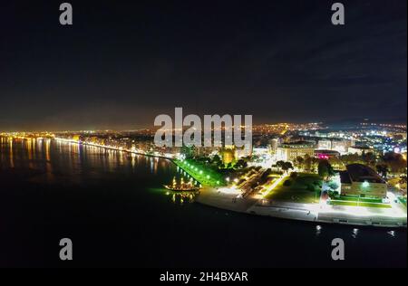 Vista aerea notturna del drone dell'area illuminata del centro della famosa città di Salonicco o Salonica, Macedonia, Grecia Foto Stock