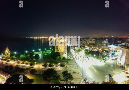 Vista aerea notturna del drone dell'area illuminata del centro della famosa città di Salonicco o Salonica, Macedonia, Grecia Foto Stock