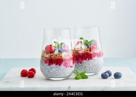 Parfait Tropico. Semi di Chia, yogurt, mirtilli, lamponi, mandorle, oat, menta. Calorie basse Foto Stock