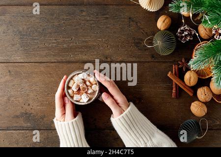 Tazza femmina senza volto di cioccolato caldo con marshmallows. Decorazioni di Natale Foto Stock