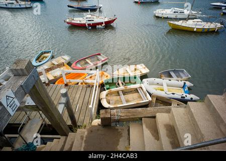 Piccoli gommoni tenui ormeggiati vicino ai gradini del porto nel porto esterno di Scarborough Foto Stock