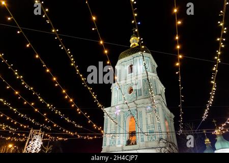 Bellissimo albero di Natale decorato scenografico con decorazioni e illuminato da ghirlande chiare contro la cattedrale di Sophia sullo sfondo di piazza Sofievska Foto Stock