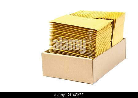 Due pile di sacchetti di fiocco in una scatola di cartone kraft isolato su bianco. Buste a bolle d'aria standard. Foto Stock