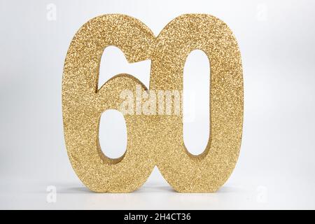 Un segno dorato glittery che dice il numero 60 su uno sfondo bianco, sessantesimo compleanno o anniversario concetto Foto Stock