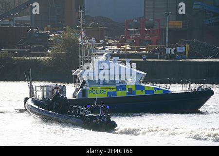 Le barche della polizia sorvegliano la nave Greenpeace Rainbow Warrior, ormeggiata al King George V Dock sul fiume Clyde, durante la vetta Cop26 a Glasgow. Data foto: Martedì 2 novembre 2021. Foto Stock