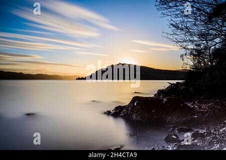 Tramonto sul Castello di Urquhart dalle rive di Loch Ness, Scozia Foto Stock
