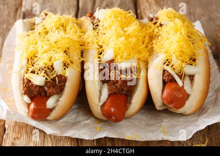 American Cincinnati Chili hot dog closeup nella carta sul tavolo. Orizzontale Foto Stock
