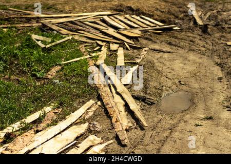 Una strada nel villaggio. Strade in Russia. Le tavole giacciono nel fango. Il luogo di passaggio dei camion sulla strada. Foto Stock