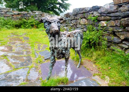 Scultura in bronzo del cane Gelert, posta in un cottage in rovina vicino alla tomba di Gelert, Beddgelert, Snowdonia National Park, Gwynedd, Galles, REGNO UNITO Foto Stock