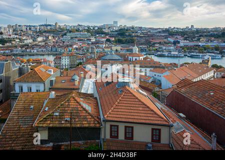 Vista della città di Porto, Portogallo attraverso antichi tetti in tegole Foto Stock