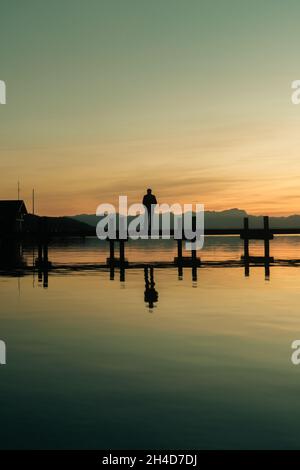 Starnberg, Germania . 2 novembre 2021. Persona steht auf Steg bei Percha, Landkreis Starnberg, bei Sonnenuntergang im Sommer. Im Hintergrund sind die Alpen zusehen. * persona in piedi sulla passerella vicino a Percha, distretto di Starnberg, al tramonto in estate. Sullo sfondo si possono vedere le Alpi. (Foto di Alexander Pohl/Sipa USA) Credit: Sipa USA/Alamy Live News Foto Stock