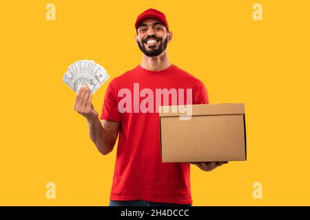 Corriere Arabo Guy Holding Money and Parcel Box, sfondo giallo Foto Stock