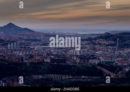 Vista della città di Bilbao al tramonto da una montagna vicina Foto Stock