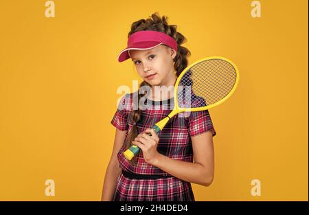 piena di energia. infanzia felice. bambino in racchetta di tenuta del cappello. bambino con racquet. ragazza teen fa l'addestramento di sport. dedicato al fitness. tennis o badminton Foto Stock