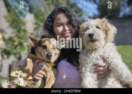 Bellissimo scatto di una femmina ispanica con i suoi due cani. Foto Stock