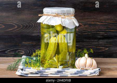 Cetrioli sott'aceto fatti in casa, aglio in vasetti su scaffale di legno alimenti fatti in casa in scatola e fermentati concetto di prodotto di stagione. Foto Stock