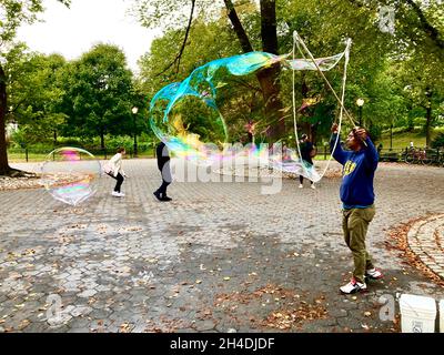 New York City, Central Park, uomo che fa la bolla gigante Foto Stock