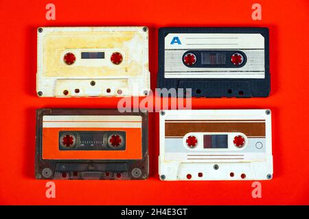 Quattro vecchie cassette audio sul primo piano della carta rossa Foto Stock