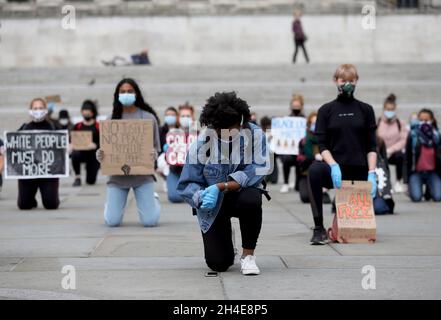 Le persone che indossano maschere facciali e guanti prendono parte a una protesta inginocchiata per la questione delle vite nere a Trafalgar Square, Londra, in memoria di George Floyd, ucciso il 25 maggio durante la custodia della polizia nella città americana di Minneapolis. Data foto: Venerdì 5 giugno 2020. Foto Stock