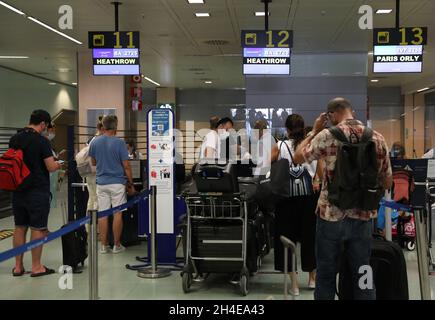 I viaggiatori sono in fila per effettuare il check-in dei bagagli presso lo sportello della British Airways dell'aeroporto internazionale di Ibiza, poiché l'industria del turismo in Spagna è stata duramente colpita dall'ultimo requisito di quarantena di 14 giorni da parte del governo britannico per tutti i turisti che viaggiano dalla Spagna a causa dei suoi alti livelli di casi COVID-19. Data foto: Sabato 1 agosto 2020. Foto Stock