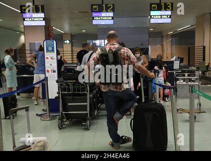 I viaggiatori sono in fila per effettuare il check-in dei bagagli presso lo sportello della British Airways dell'aeroporto internazionale di Ibiza, poiché l'industria del turismo in Spagna è stata duramente colpita dall'ultimo requisito di quarantena di 14 giorni da parte del governo britannico per tutti i turisti che viaggiano dalla Spagna a causa dei suoi alti livelli di casi COVID-19. Data foto: Sabato 1 agosto 2020. Foto Stock